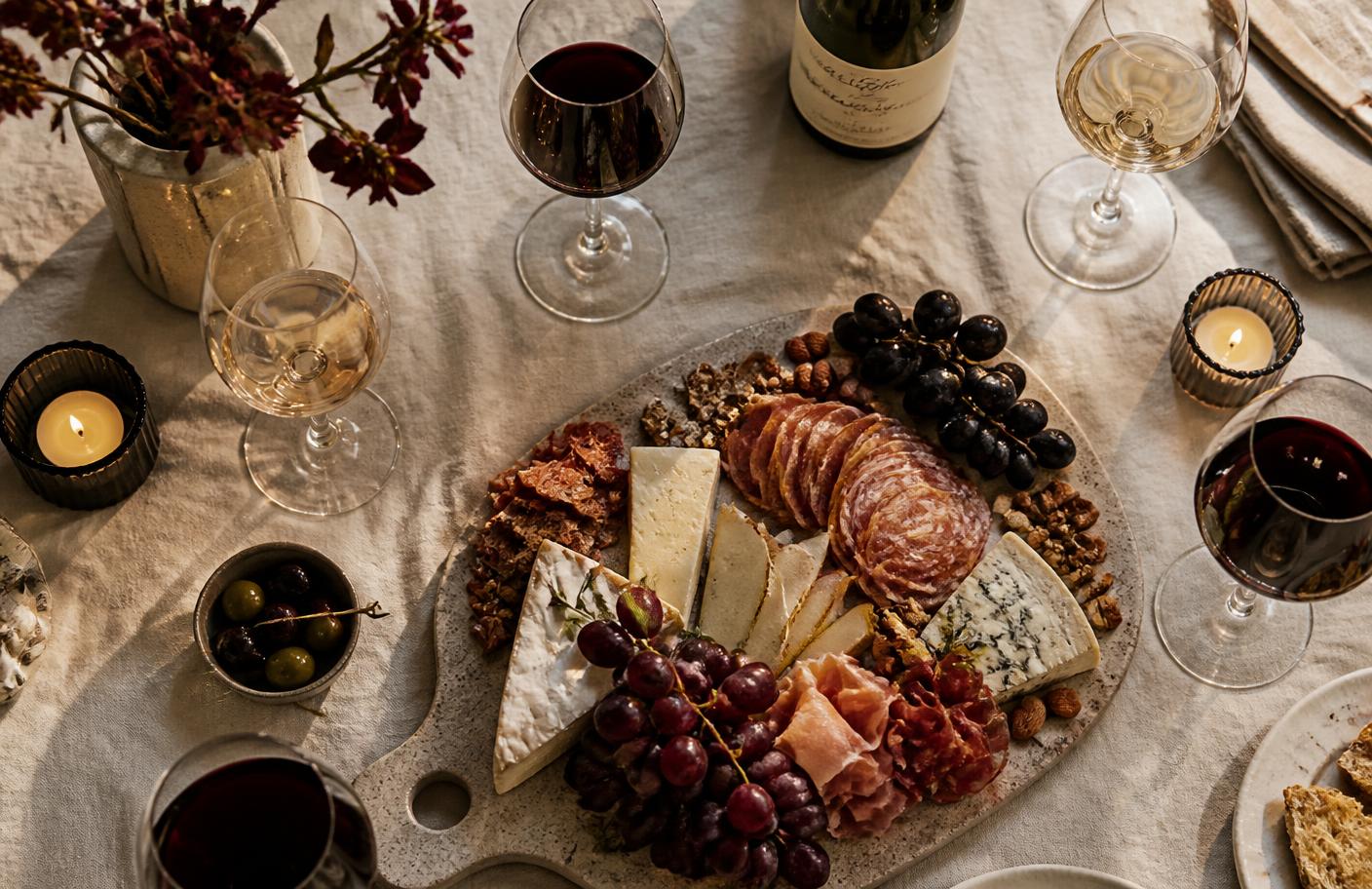 Masă de degustare cu pahare de vin și platou de brânzeturi